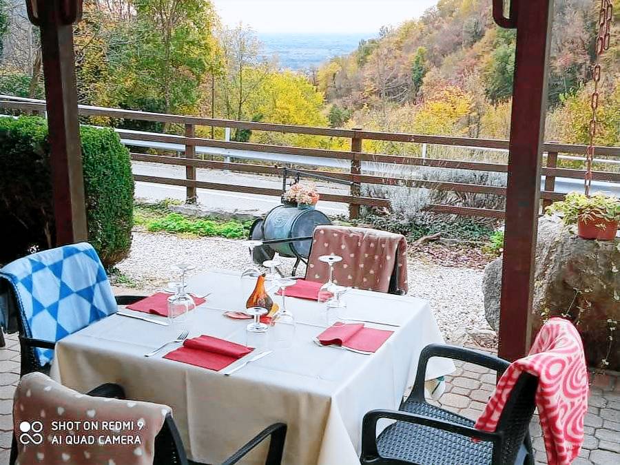 Tavolo apparecchiato sotto il pergolato esterno