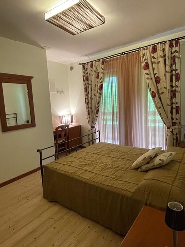 Camera Viola - letto matrimoniale e tendaggi coordinati